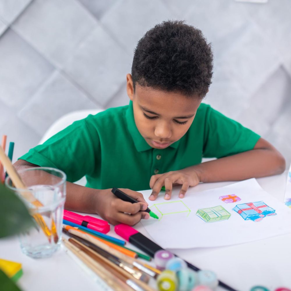 boy-drawing-with-colored-marker-sitting-table